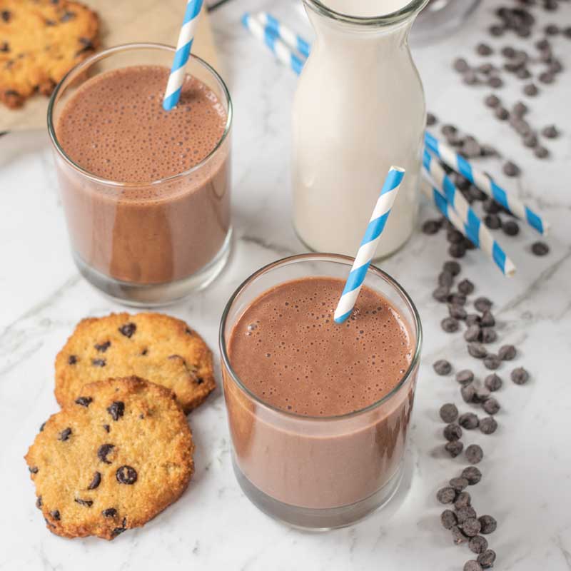 Keto Chocolate Milk in a glass with chocolate chip cookies next to it