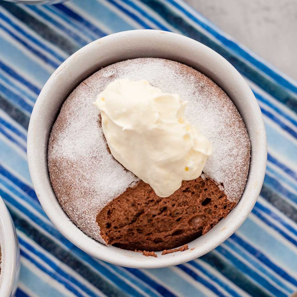 Keto Chocolate Souffle topped with whipped cream on a striped blue napkin